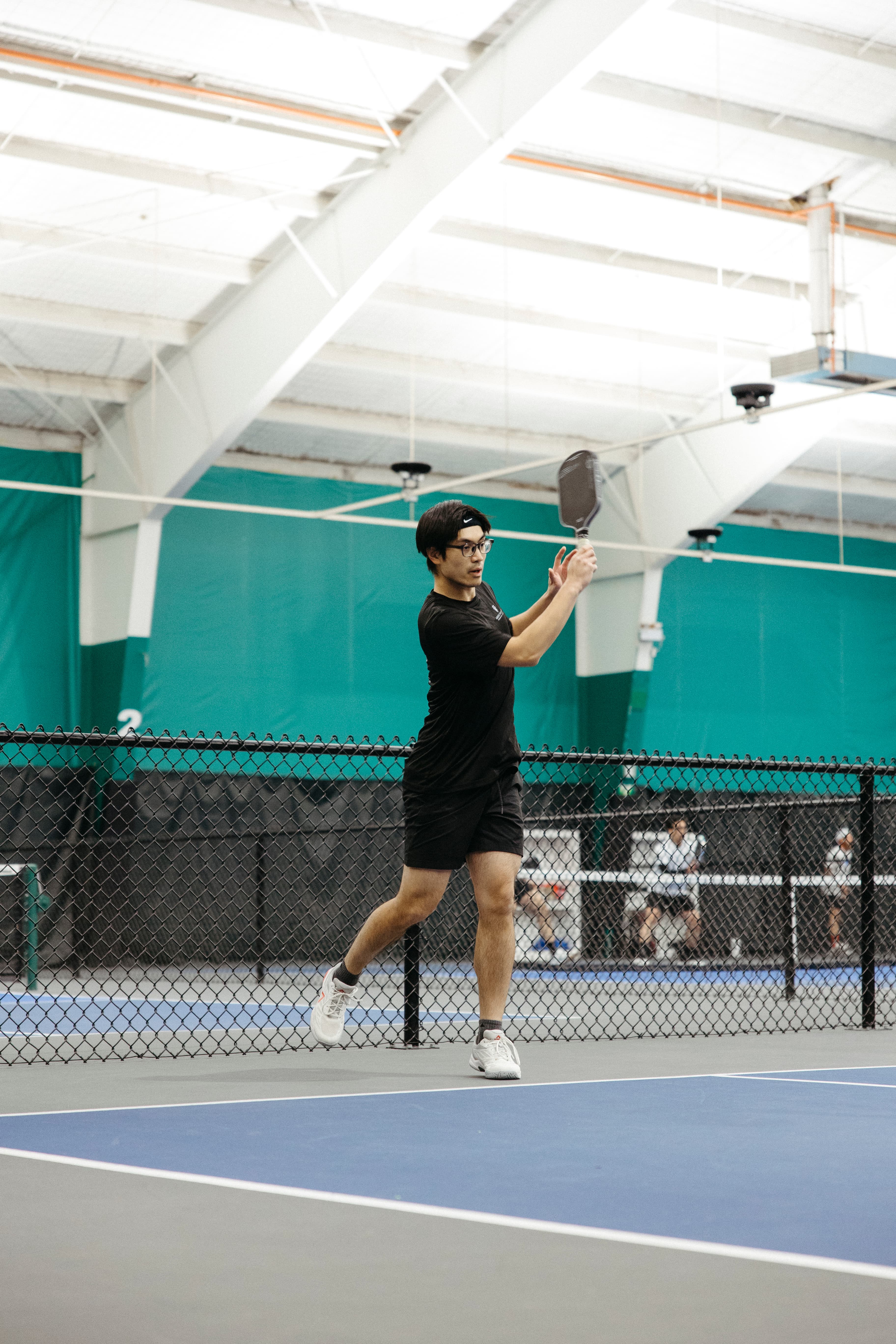Pickleball player executing an overhead smash in a Klyng Cup inter-club match